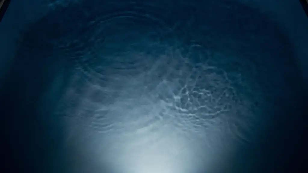 Blue light rippling across a pale pool floor at night